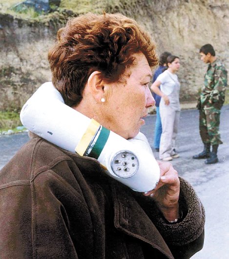 Elvia Cortes Gil de Pachon sostiene un collar de explosivos minutos antes de que explotara, en Chiquinquira, a 110 km al norte de Bogota el 15 de mayo del 2000. La senora Cortes, una hacendada de la region, soporto durante 6 horas el explosivo antes de la explosion, matandola a ella y a un oficial de la policia que trataba de desactivar el artefacto. El presidente de Colombia, Andres Pastrana, anuncio el 16 de Mayo del 2000, la suspension de una reunion internacional sobre narcocultivos con la guerrilla de las Fuerzas Armadas Revolucionarias de Colombia (FARC) programada para fines de Mayo, debido a este hecho se le atribuye a las FARC.  AFP PHOTO/EL TIEMPO