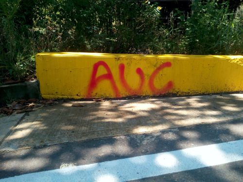 marcas con letras rojas (AUC) fueron ´pintadas en los bordes de la carretera marcas con letras rojas (AUC) fueron ´pintadas en los bordes de la carretera